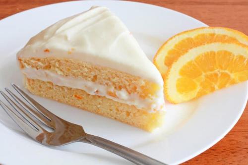 a piece of cake on a plate with an orange slice at La Settima Luna Hotel in Canneto