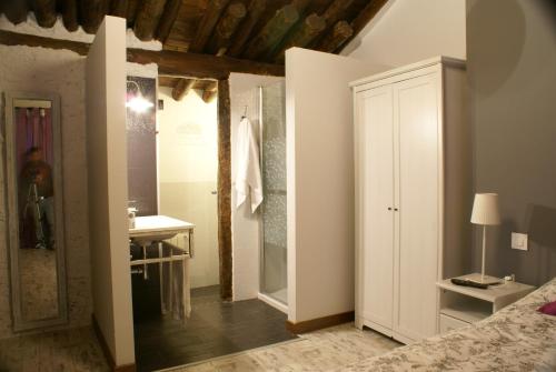 a bedroom with a bathroom with a sink and a mirror at El Pajar de la Abuela in Arcas