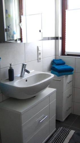 a white bathroom with a sink and a mirror at Gästezimmer Waldblick in Wimbach
