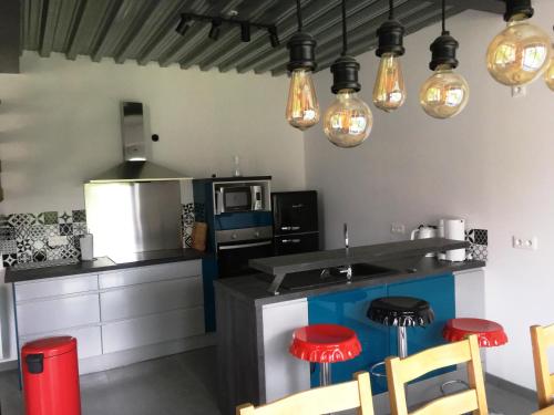 a kitchen with a counter and some lights at Gite de sejour la grange de Théophile in Anzin-Saint-Aubin