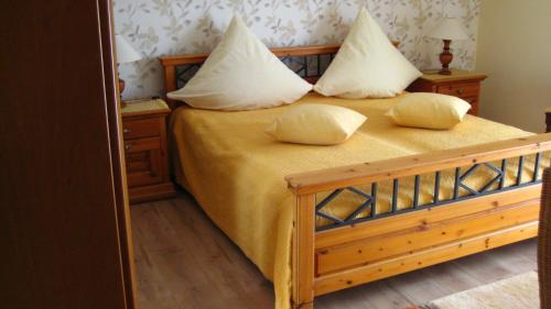 a bedroom with a bed with yellow sheets and pillows at Gästezimmer Waldblick in Wimbach