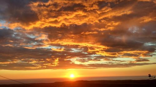 a sunset with the sun setting in the sky at Su 'e Torigheddu - Casa con terrazza panoramica in Cuglieri
