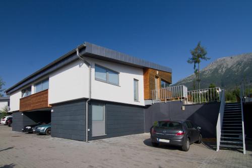 a house with a car parked in front of it at Mountain Villas Polana in Smokovce