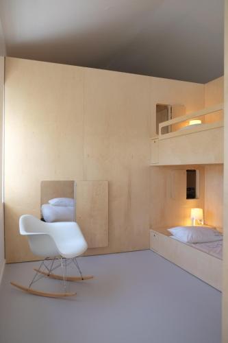 a white chair in a room with two beds at Porto Serralves Designing Apartment in Porto
