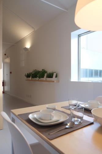 a dining room table with plates and glasses on it at Porto Serralves Designing Apartment in Porto
