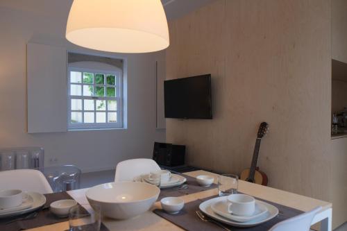 a dining room with a table with bowls and plates on it at Porto Serralves Designing Apartment in Porto