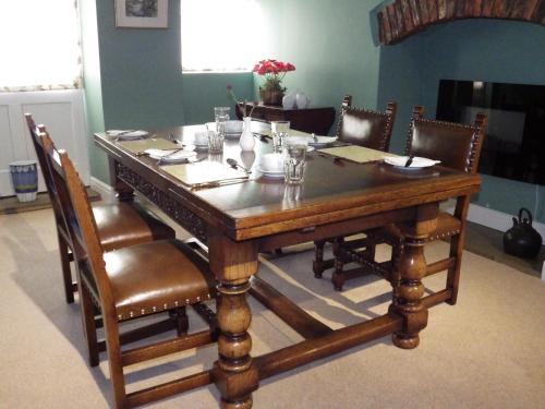 een houten tafel met stoelen en een eetkamer bij Pond Farm in Pickering