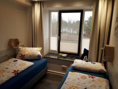 a small room with a bed and a window at Ankerplatz am Südstrand, Fewo mit 2 Schlafzimmer und eigenen Strandkorb in Binz