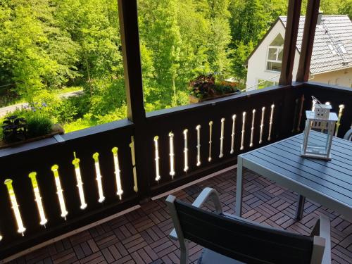 a balcony with a table and chairs and a window at Apartmenthaus Luise in Bad Schandau