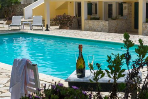 a bottle of wine sitting on a table next to a swimming pool at Villa Elaia Suites & Apartments No.1 in Gaios