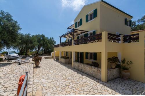 a large yellow building with a parking lot at Villa Elaia Suites & Apartments No.1 in Gaios