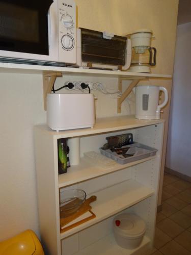 - une étagère avec un four micro-ondes et d'autres ustensiles de cuisine dans l'établissement Studio n°1 agréable et bien situé, à Amélie-les-Bains-Palalda