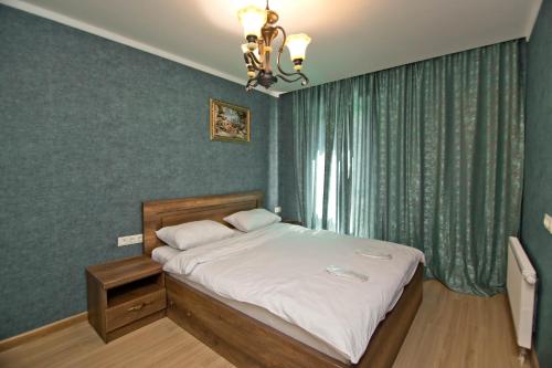 1 dormitorio con cama y lámpara de araña en Orbi Bakuriani apartment 731 en Bakuriani