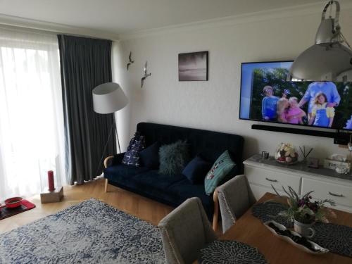 a living room with a couch and a flat screen tv at Apartament na Morskim Wzgórzu in Mechelinki