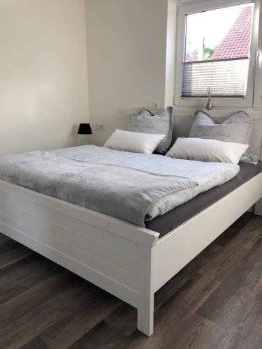 ein großes weißes Bett in einem Schlafzimmer mit Fenster in der Unterkunft Ferienwohnung Calla in Erfurt