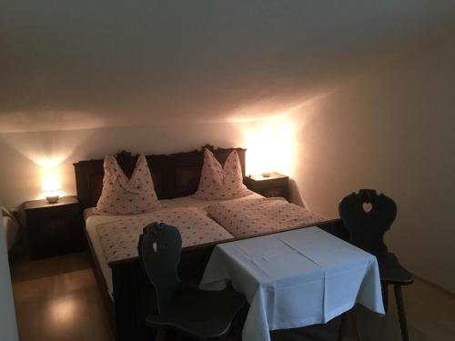 a bedroom with a bed with a table and chairs at Oberhub am Kleinsonnberg in Taxenbach