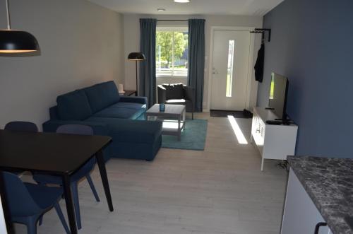 ein Wohnzimmer mit einem blauen Sofa und einem Tisch in der Unterkunft Einemo Apartments in Lærdalsøyri