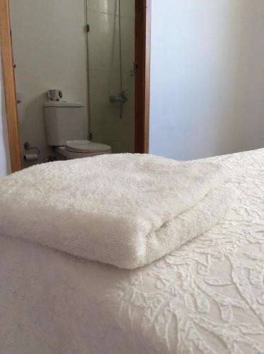 a white blanket laying on a bed in a bathroom at Oasis Palma Real santiago, Republica Dominicana in Santiago de los Caballeros