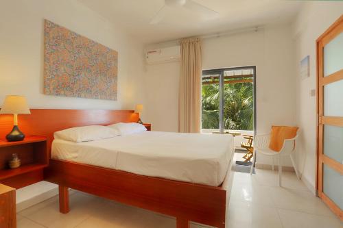 a bedroom with a large bed and a window at Auberge SeaFever in Mahébourg