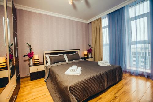 a bedroom with a bed with two towels on it at Sea Towers Suite in Batumi