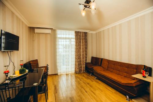 a living room with a couch and a television at Sea Towers Suite in Batumi