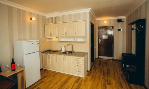 a kitchen with a white refrigerator and a sink at Sea Towers Suite in Batumi
