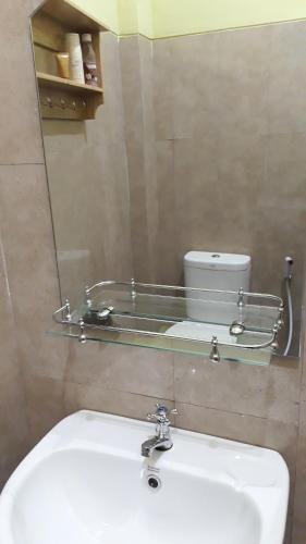 a mirror above a sink in a bathroom at Omah Wilis in Batu