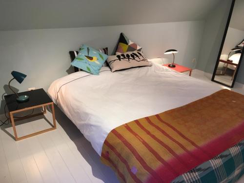 sypialnia z dużym łóżkiem z poduszkami i stołem w obiekcie La dreve w mieście Verviers