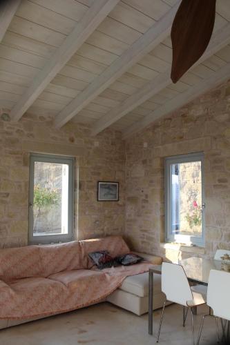 a living room with a couch and two windows at Villa Bianca in Ferma