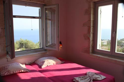 een slaapkamer met een roze bed en 2 ramen bij Villa Bianca in Ferma