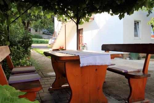 a table and two benches sitting next to a building at Apartman Sofia in Otočac