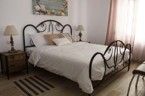 1 dormitorio con 1 cama grande con sábanas y almohadas blancas en Blue Island, en Batsi