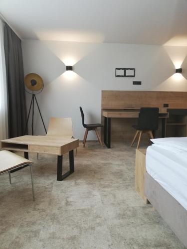 a bedroom with a bed and a desk and a piano at Hotel Prebold in Prebold