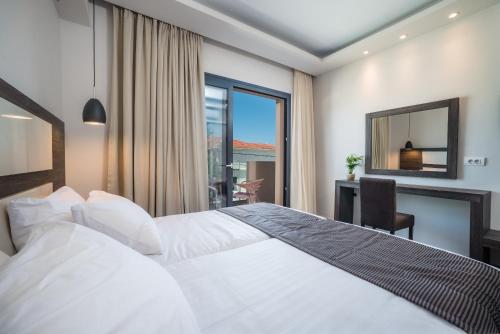 una camera d'albergo con letto, scrivania e finestra di ABATON Luxury Resort a Tsilivi