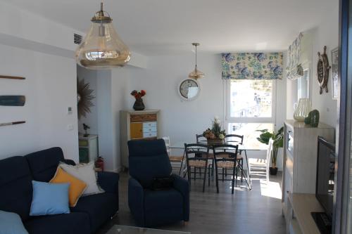 salon z niebieską kanapą i stołem w obiekcie Dúplex playa Cabria w Almuñécar