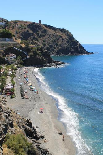 a beach with a bunch of people and the ocean at Dúplex playa Cabria in Almuñécar