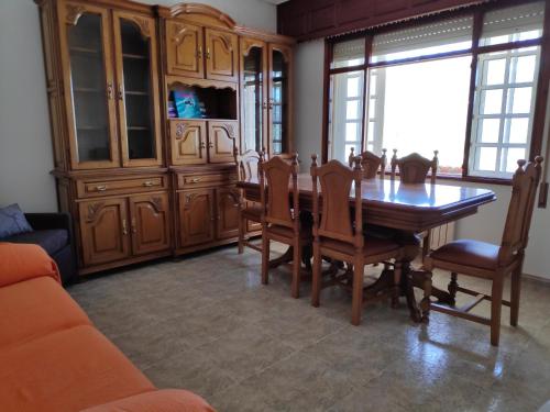 a dining room with a wooden table and chairs at Casa en primera linea de playa en Pantin!! in Pantín