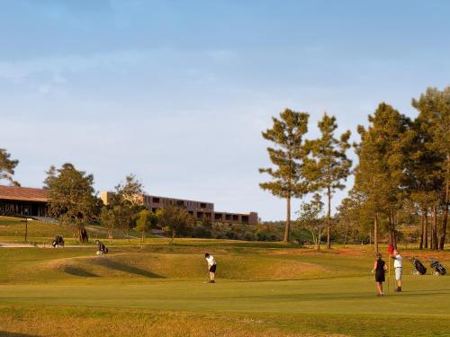 a group of people playing golf on a golf course at NAU Morgado Golf & Country Club in Portimão