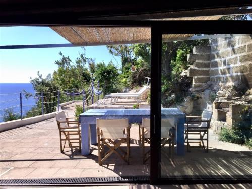a table and chairs on a patio with a view of the ocean at VILLE GIRASOLI "VILLA NELLA BAIA" with PRIVATE SWIMMING POOL in Tricase