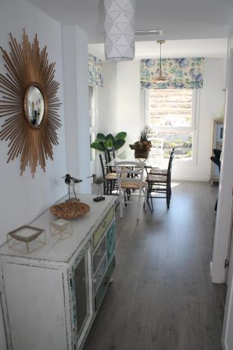 a living room with a table and a mirror on the wall at Dúplex playa Cabria in Almuñécar