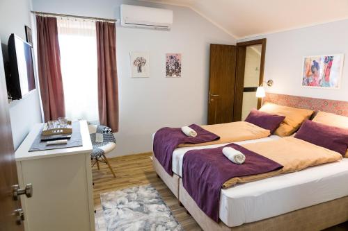 a bedroom with a bed and a desk in it at SoleGutta in Kolárovo