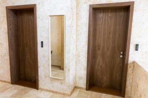 two wooden doors in a bathroom with a mirror at SoleGutta in Kolárovo
