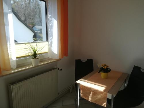 Habitación con mesa, 2 sillas y ventana en Ferienwohnung Düne, en Ostseebad Sellin