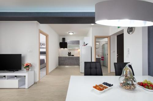 eine Küche und ein Wohnzimmer mit einem weißen Tisch und Stühlen in der Unterkunft Villa Apartments Kordić in Kaštela