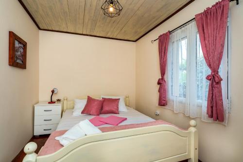 a bedroom with a white bed and a window at Guest House Luna in Virpazar