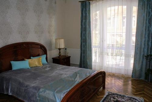 a bedroom with a bed and a large window at Parva Villa in Miskolc