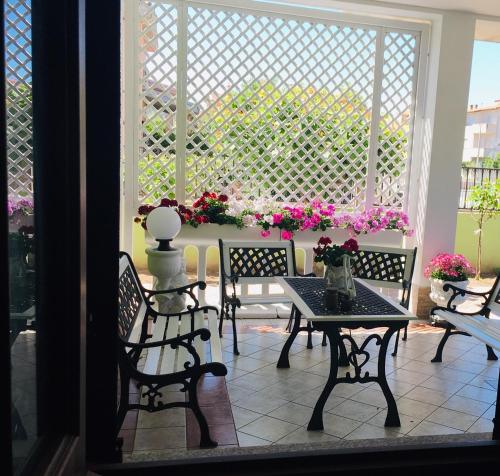 a patio with a table and chairs and flowers at La Dea Hestia in Bosa