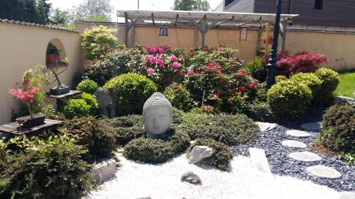 a garden with a statue in the middle at Fleur de Vigne in Eguisheim