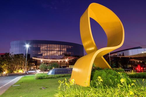 a yellow sculpture in front of a building at night at Royal Tulip Brasília Alvorada in Brasilia