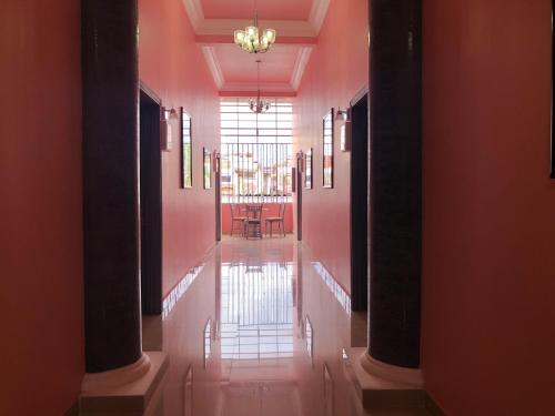 a hallway with a dining room with pink walls at Santa Fe Hotel Boutique in Tapachula